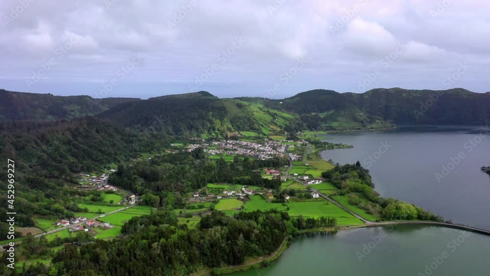 Aerial Beautiful Shot Of Structures Over Green Landscape, Drone Flying On Sea Against Cloudy Sky - Azores, Portugal Aerial Beautiful Shot Of Structures Over Green Landscape, Drone Flying On Sea Against Cloudy Sky - Azores, Portugal