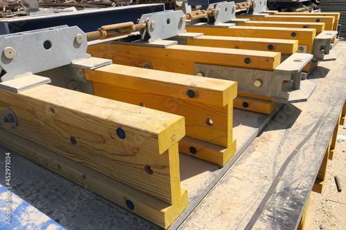 Stacked formwork made of yellow wooden beams using for concrete cast in place works photo