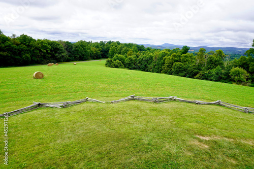 View from lookout tower at Groundhog Mountain on Virginia portion of the Blue Ridge Parkway. Split-rail fence, round hay bales or rolls. Buffalo Mountain in the distance.  photo