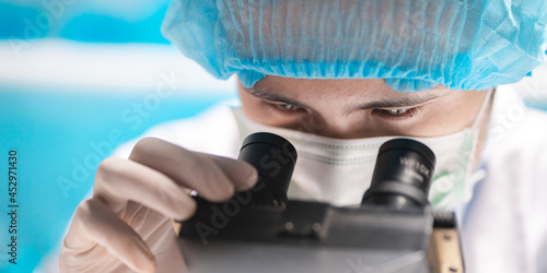 scientist looking through s...