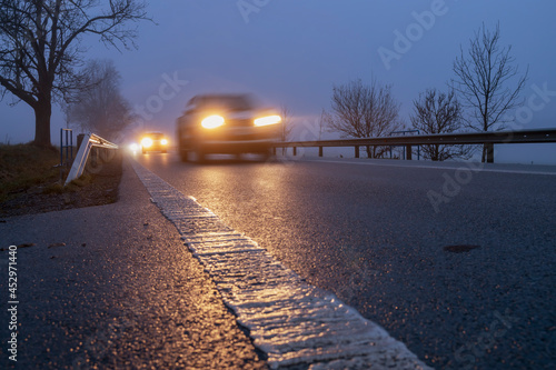 Foto Lighted cars at dusk on  main road