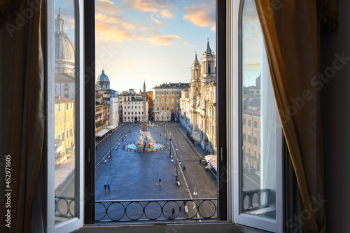 View from an open window overlooking the Piazza Navona at sunrise showing Bernini's Fountain of Four Rivers. photo