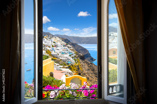 View from a resort window overlooking the whitewashed town of Oia, Santorini, Greece and the Aegean Sea.
