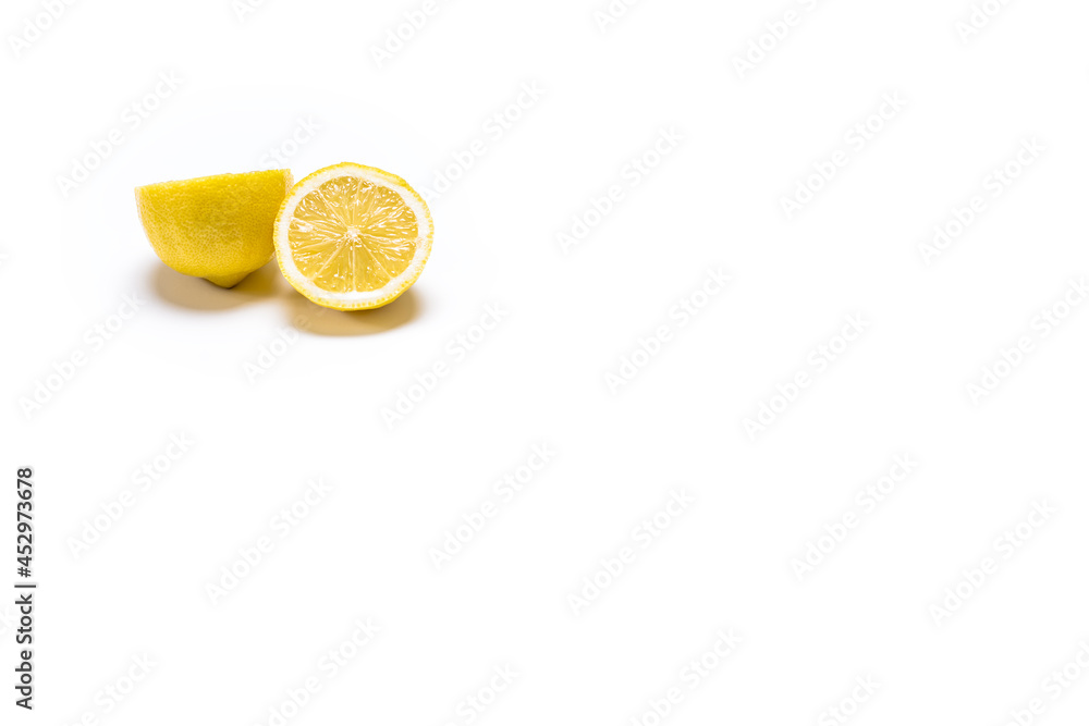 Photography of a yellow lemon in two halves on a white background.The photo has copy space and is shot in horizontal format. Photography of a yellow lemon in two halves on a white background.The photo has copy space and is shot in horizontal format.