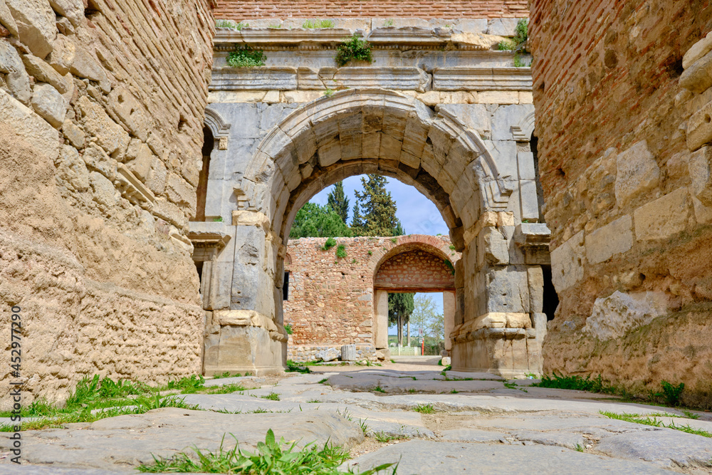One of the entrance gate of ancient city of iznik (nicaea) made of red bricks stones city walls and stairs by taken photo during sunny day and ancient architecture arch and sky low angle photo.