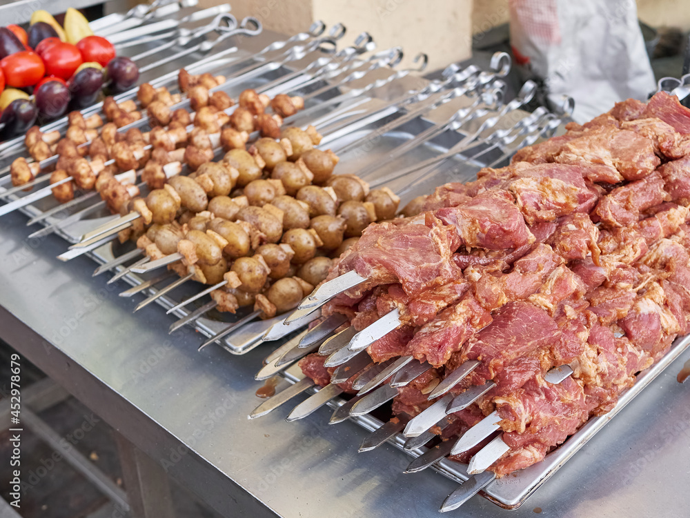 There are a lot of meat and vegetable skewers on the counter. Street food concept.