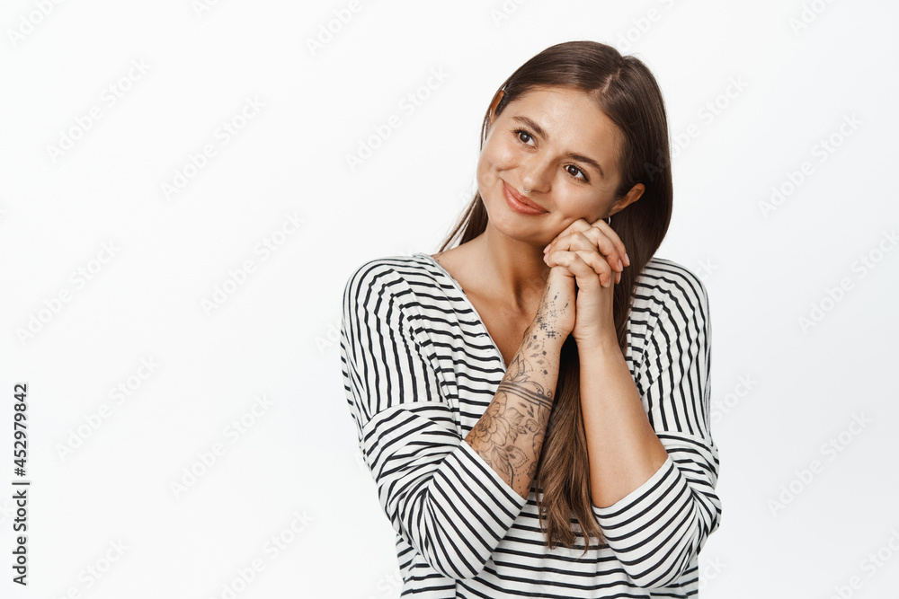 Dreamy romantic woman looking aside, lean head on hands and daydreaming, picturing something beautiful with pleased smile on her face, white background Dreamy romantic woman looking aside, lean head on hands and daydreaming, picturing something beautiful with pleased smile on her face, white background