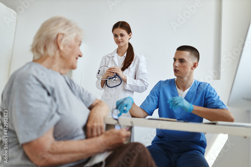 elderly woman patient in doctor s office with nurse communicating
