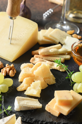 Obraz na plátně Cheese platter with grapes, nuts, figs on black slate plate