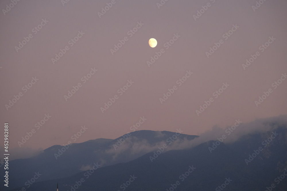 Full moon on the mountain of grand (uludag, bursa) during night with mist and fog on the mountain peak