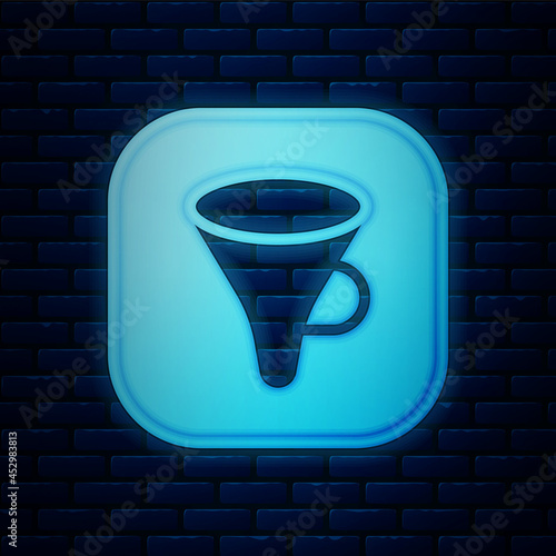 Glowing neon Funnel or filter icon isolated on brick wall background. Vector
