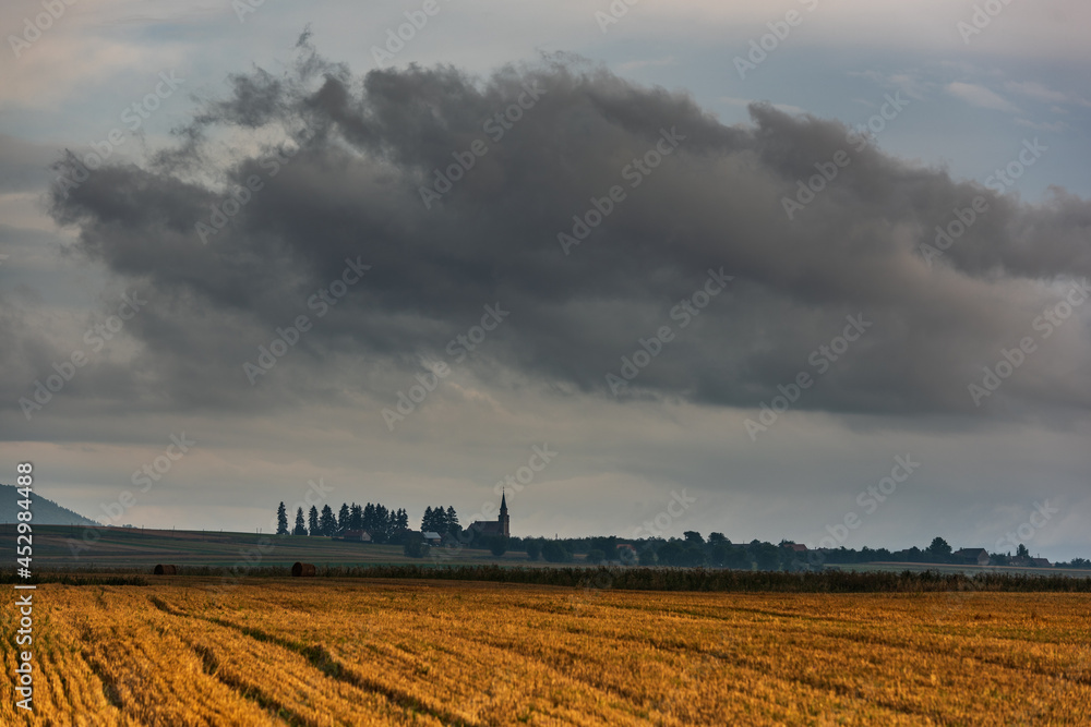 Fototapeta premium The sky with storm clouds over the village. Summer rural landscape.