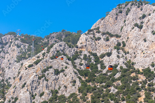 cable car carrying passengers over the mountain, blue sky background. tunektepe, antalya, turkey, photo