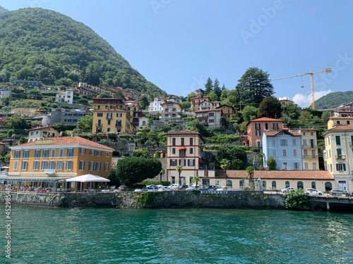 Skyline of Argegno town with houses on hills and mountains. Landscape of Como Lake (Lago di Como). View from the boat of cityscape and nature. Argegno, Como Lake, Lombardy, Italy