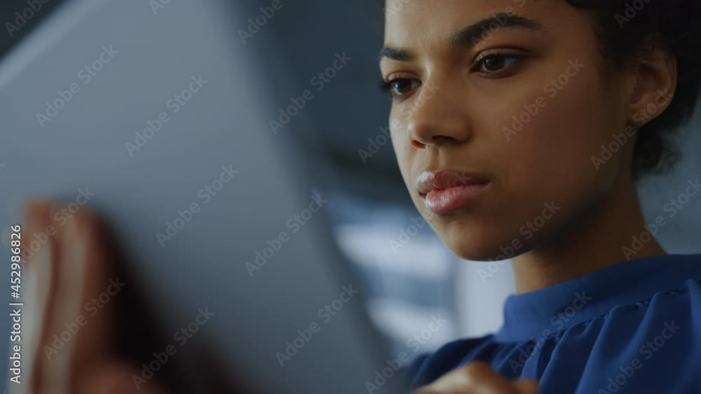African business woman reading financial report on tablet computer African business woman reading financial report on tablet computer