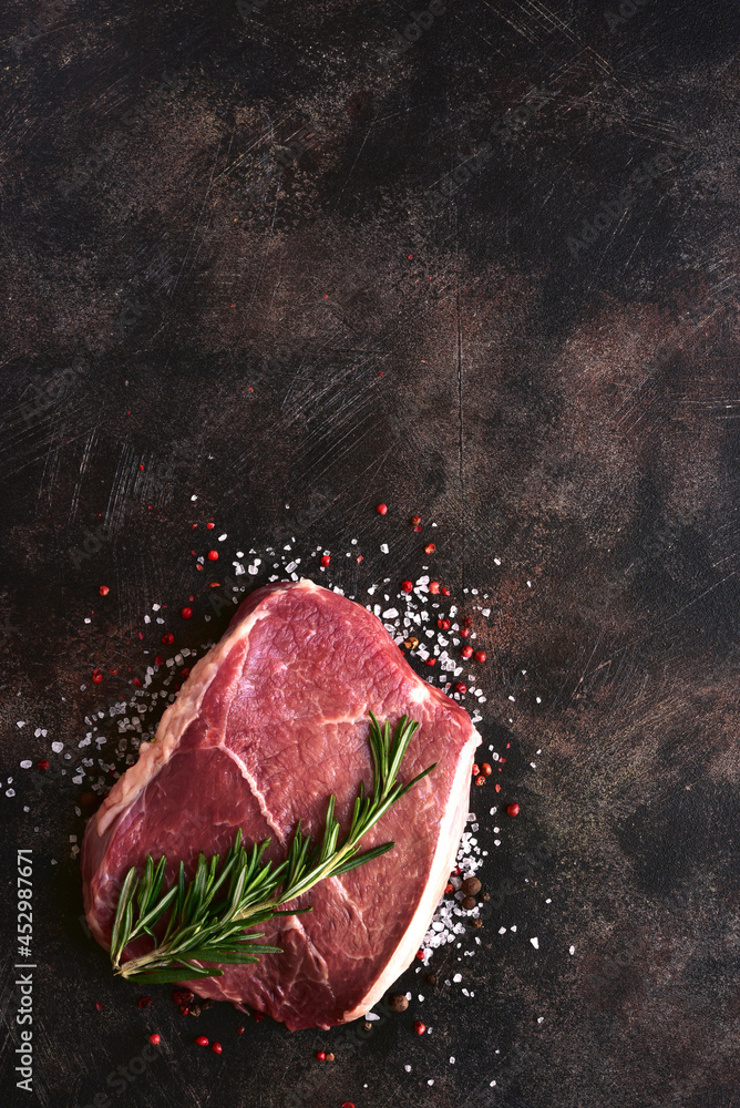 Fresh raw marbled beefsteak with spices . Top view with copy space.
