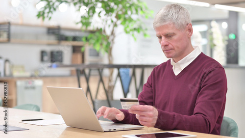 Successful Old Businessman Doing Online Shoppingon Laptop photo