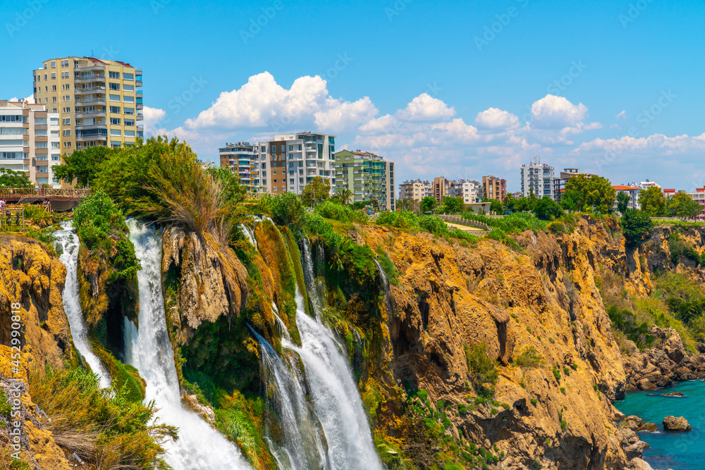 Fototapeta premium Lower Düden Falls drop off a rocky cliff falling from about 40 m into the Mediterranean Sea in amazing water clouds. Tourism and travel destination photo in Antalya, Turkey.