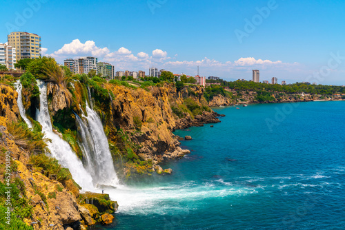 Lower Düden Falls drop off a rocky cliff falling from about 40 m into the Mediterranean Sea in amazing water clouds. Tourism and travel destination photo in Antalya, Turkey.