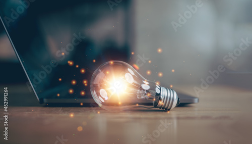 light bulb with laptop computer, idea of ​​inspiration from online technology, innovation idea concept, Self learning or education knowledge and business studying concept. photo