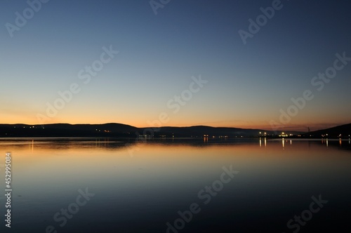 Evening view of the Kola Bay Murmansk is the main port in the north of Russia. Beautiful sunset with the reflection of the lights in the bay. Beautiful landscape on the side of Cape Abram.