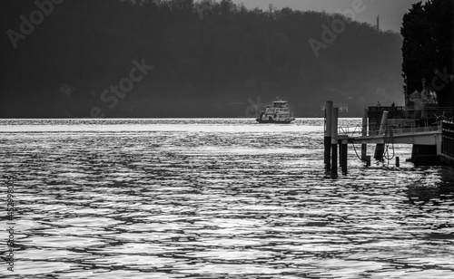 Obraz na płótnie A small ship zigzags from one side to the other of Lake Como