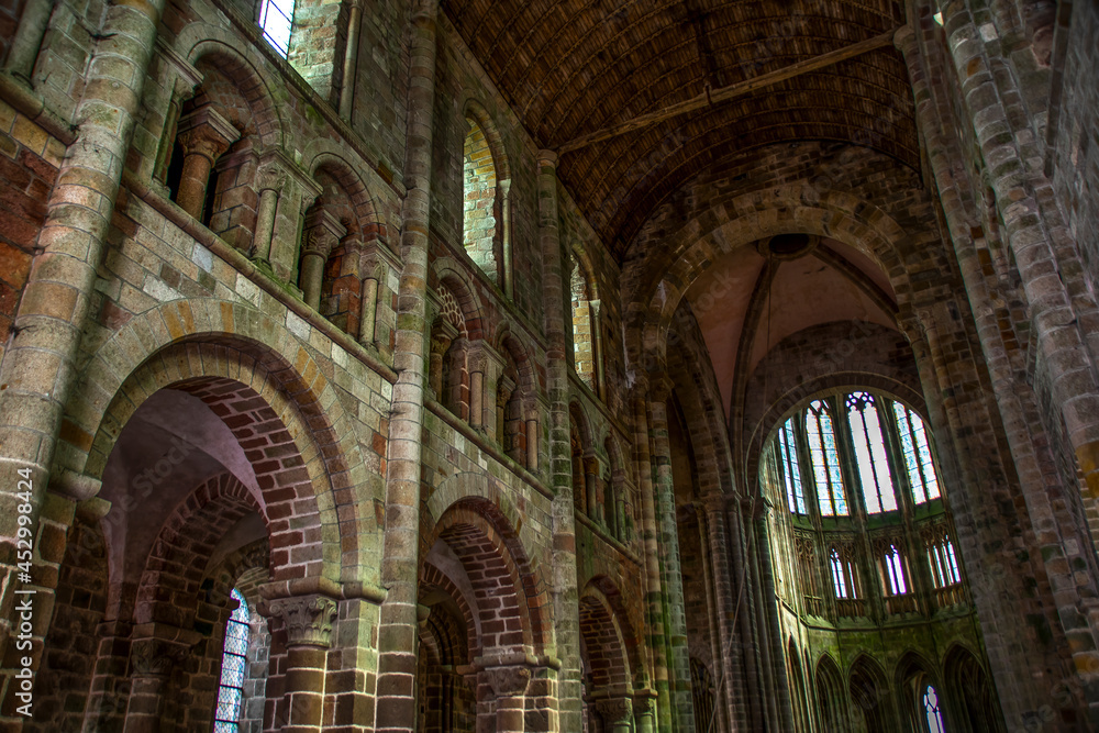 An interior view of the vast walls and arched doorways and ceilings in the medieval abbey of Mont Saint Michel in France. An interior view of the vast walls and arched doorways and ceilings in the medieval abbey of Mont Saint Michel in France.