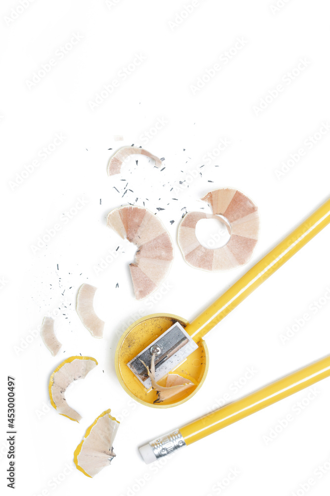 Graphite pencil, sharpener and shavings on white table. Graphite pencil, sharpener and shavings on white table.