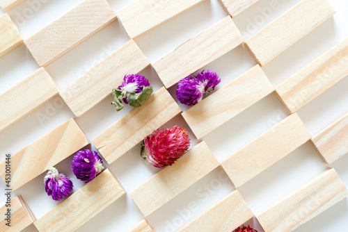 wooden blocks with globe amaranth blossoms on white