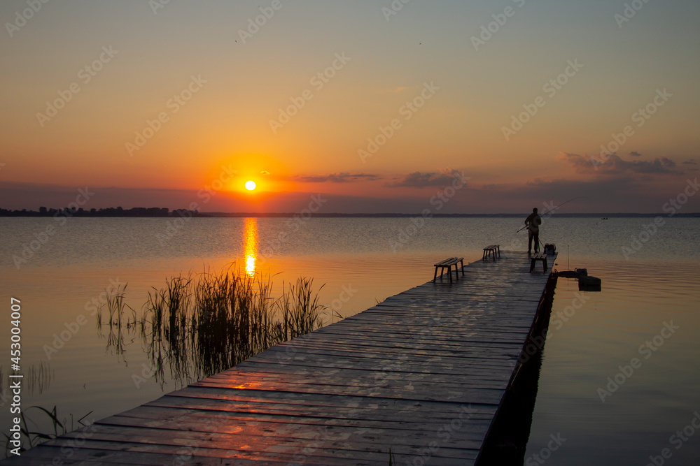 Fishing with a spinning rod at dawn. Rising Sun.