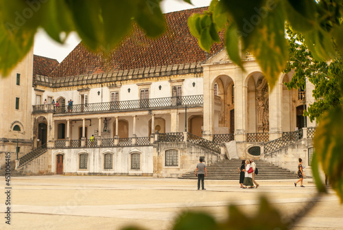 Glance at the empty touristic Paco das Escolas Square of University of Coimbra through the tree leaves frame - Selective focus, Portugal