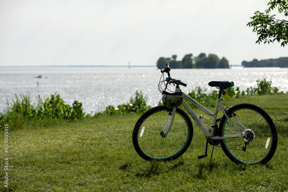 Vue d'une bicyclette stationnée sur le bord de l'eau en été avec vue sur le fleuve