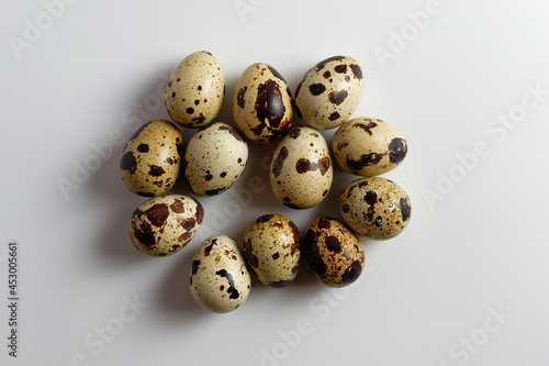 Several quail eggs seen from above, isolated on white background