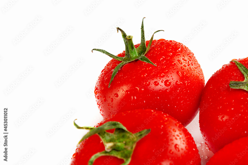 Ripe juicy red tomatoes in droplets of water on a white background Ripe juicy red tomatoes in droplets of water on a white background