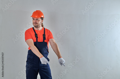 in blue overalls, a smart worker stands