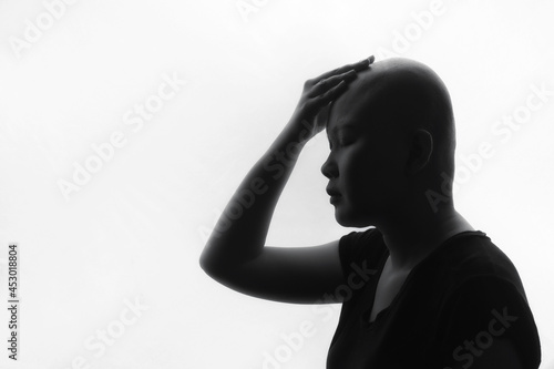 Portrait of a beautiful young courageous smiling female cancer patient, with shaved head. Gorgeous woman, a cancer patient, portrait on dark background.