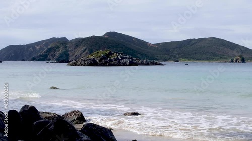 Rocky outcrop island on scenic Matai Bay on Karikari Peninsula in North Island, New Zealand Aotearoa. Remote wild beach. photo