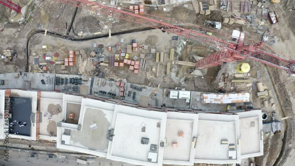Overhead view of a construction site with cranes and building material.