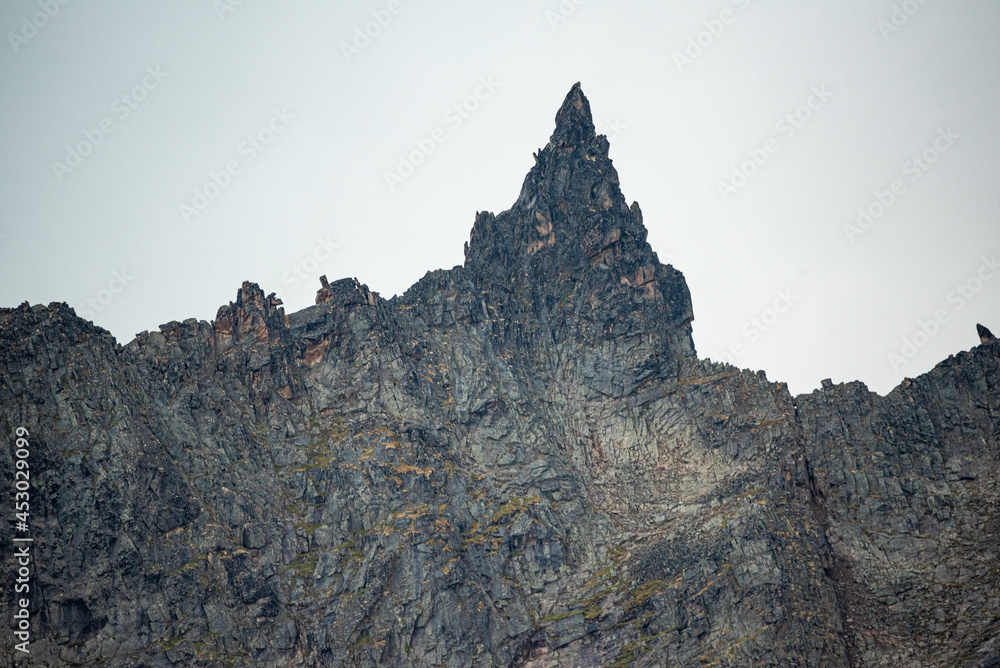 Jagged mountain peaks in northern Canada on a cloudy day with stunning landscape background. 
