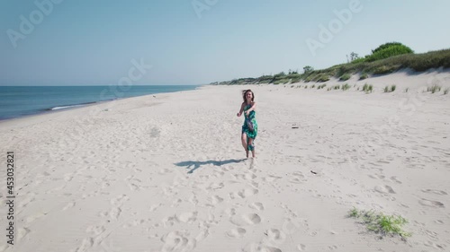 Aerial view. Beautiful woman in a blue dress on the shore of the baltic sea. photo