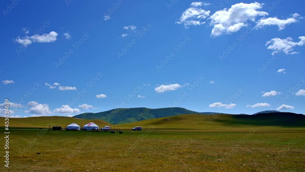 White clouds flowing under blue sky and yurts on grassland. Time-lapse White clouds flowing under blue sky and yurts on grassland. Time-lapse