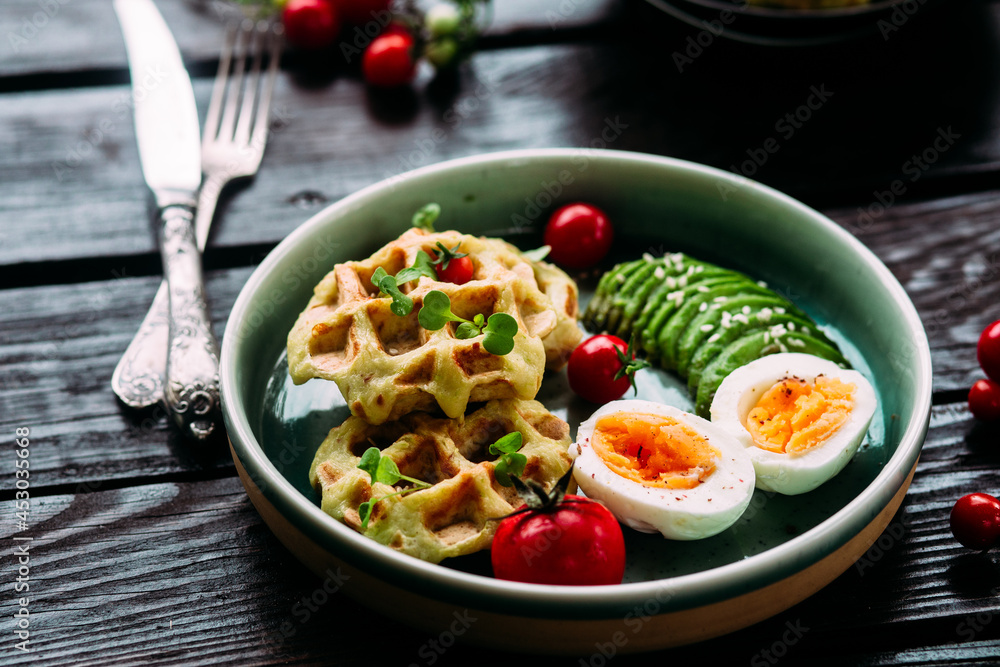 Belgian waffles with avocado, egg and tomato. Healthy breakfast