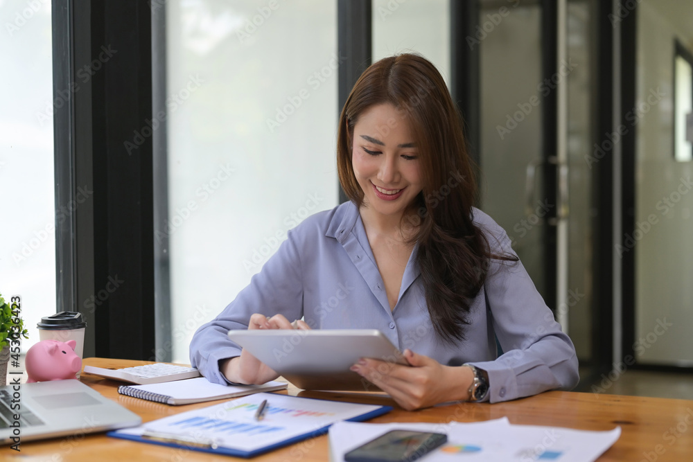 Female accountant using digital tablet at office desk. Female accountant using digital tablet at office desk.