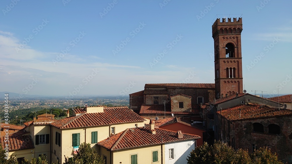 Ciel bleu avec quelques nuages sur une vieille ville en Toscane