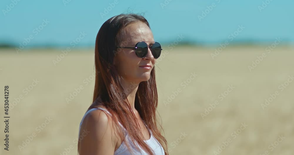 Portrait, a beautiful young woman enjoying life, a walk in the golden field. Happy woman in sunglasses smiles. 4k, ProRes Portrait, a beautiful young woman enjoying life, a walk in the golden field. Happy woman in sunglasses smiles. 4k, ProRes