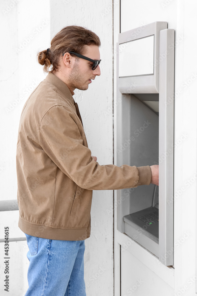 Man withdrawing money from ATM Man withdrawing money from ATM