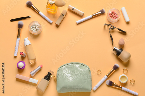 Frame made of stylish bag and decorative cosmetics on color background