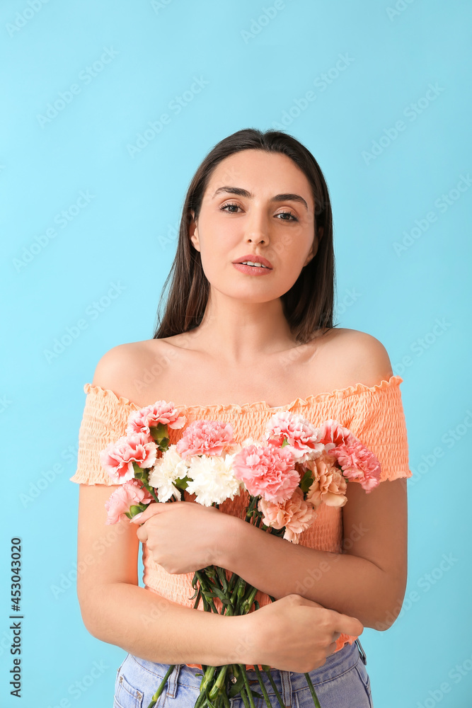 Young woman with beautiful carnation flowers on color background Young woman with beautiful carnation flowers on color background