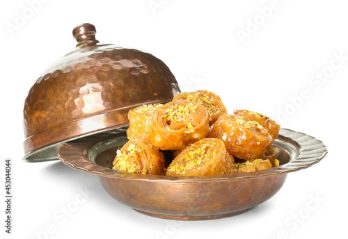 Plate with delicious baklava on white background