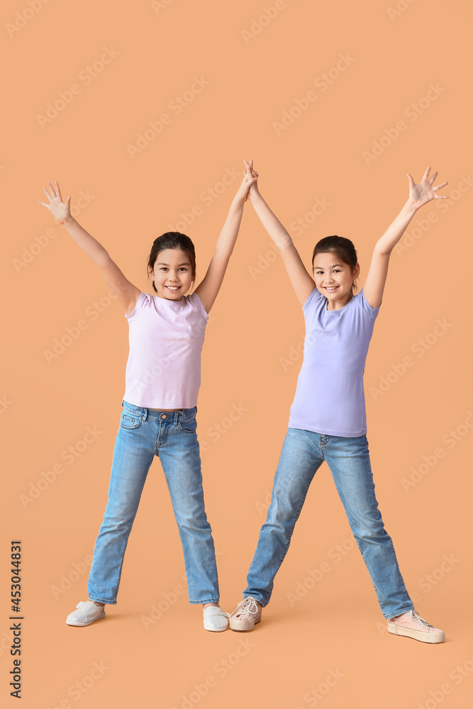 Happy little sisters on color background Happy little sisters on color background